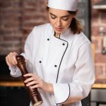 woman cook with pepper mill in the kitchen PVBRXVJ